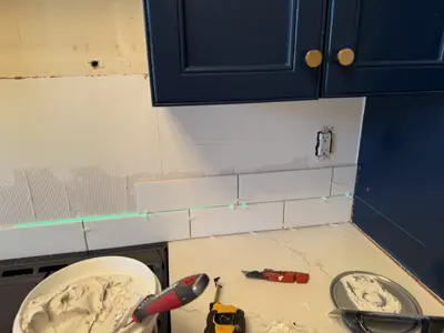 kitchen backsplash subway tile installation in progress with laser level alignment, nyc