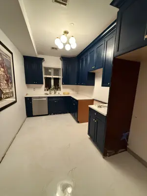 freshly painted navy blue kitchen cabinets with white subway tile backsplash and marble-look flooring in nyc