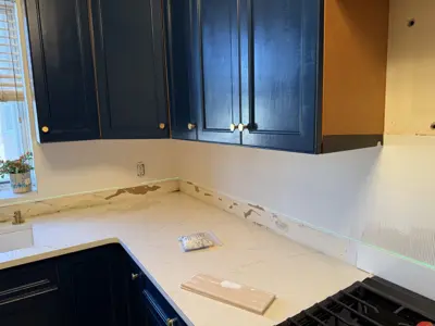 kitchen renovation in progress with freshly painted navy blue cabinets and new marble countertops in nyc