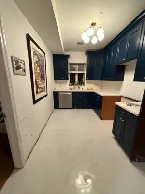 completed navy blue cabinet painting and white marble vinyl flooring in a bright nyc kitchen