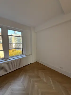 Freshly painted white walls in a NYC apartment with herringbone hardwood floors and natural light