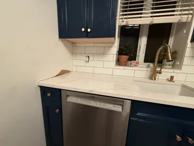 bosch dishwasher installed in renovated nyc kitchen with blue cabinets and white subway tile backsplash