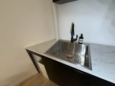 completed modern stainless steel sink and black faucet installation on marble countertop in nyc kitchen
