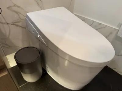 Newly installed modern smart toilet in a luxury marble-tiled NYC bathroom