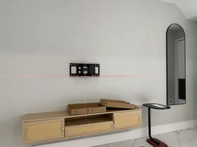 tv wall mount bracket being leveled with laser level tool in a modern nyc living room