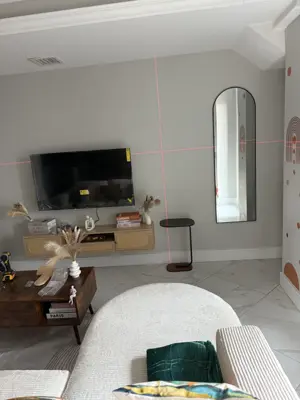 laser level used to align tv wall mount and mirror placement in nyc living room