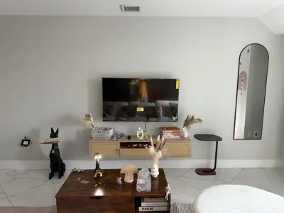 large flat-screen tv wall mounted in modern nyc living room with floating media console