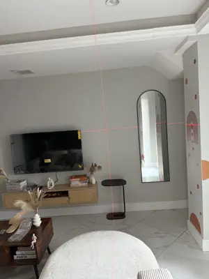 laser level lines projected on living room wall during tv or mirror mounting project in nyc