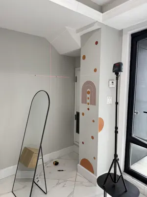 laser level setup for precise tv or mirror wall mounting in modern nyc apartment with decorative wall art
