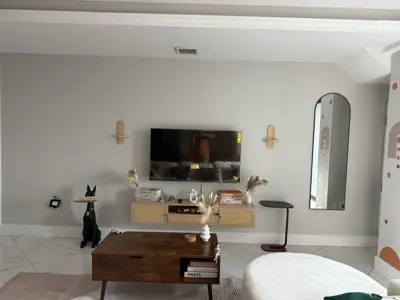 completed tv wall mount installation in a modern nyc living room with floating media console and wall sconces