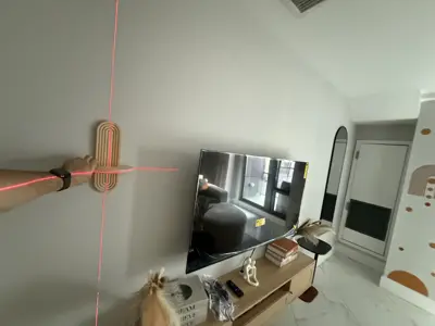 technician using laser level for precise tv wall mounting alignment in modern nyc living room