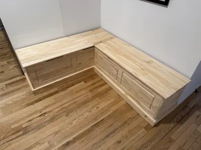 L-shaped natural pine wood storage bench assembled in NYC living space corner
