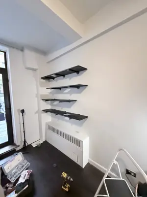 Floating shelf installation on apartment wall