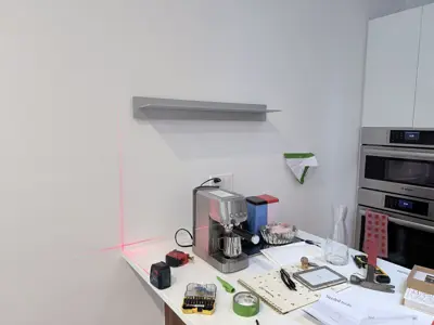 Floating shelf installation on apartment wall