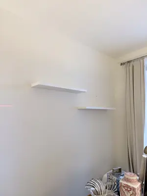Floating shelf installation on apartment wall