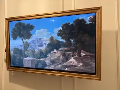 Samsung Frame TV flush-mounted on white wall showing classic landscape painting in NYC apartment