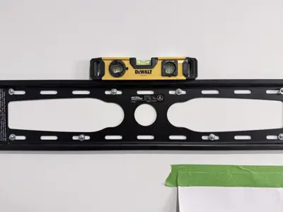TV wall mount bracket being leveled with DeWalt level during professional installation in NYC