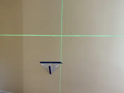 laser level and wall bracket positioned for precise tv or shelf mounting in nyc home