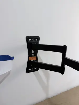 TV mounting bracket installation — wall-anchored support system