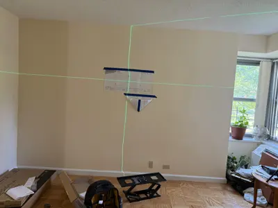 Laser level used for precise TV wall mount bracket alignment in NYC living room