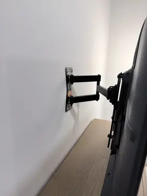 TV mounting bracket installation — wall-anchored support system