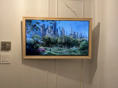 Samsung Frame TV wall-mounted in elegant NYC apartment with gold trim on white wainscoting panel